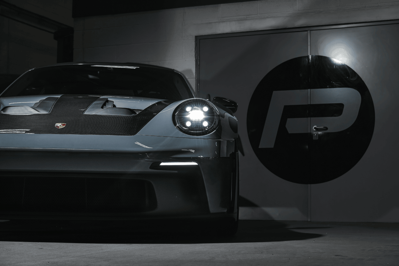 A rear angle view of the 992.1 Porsche Turbo S in the Performance Workshop with the Akrapovic performance exhaust system installed, showcasing its seamless integration and craftsmanship.