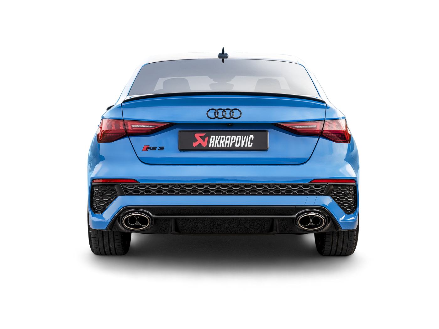 An image showing the rear quarter of both Sedan and Sport back versions of the Audi RS 3 8Y. Both fitted with Akrapovič Evolution Line exhaust systems, and Akrapovič carbon fibre rear diffusers.