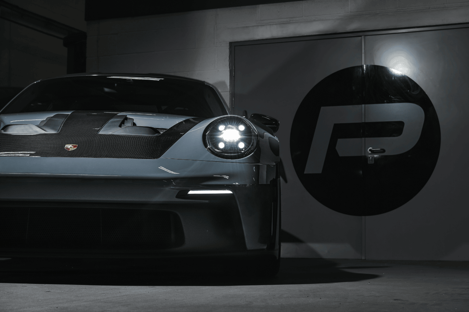 A rear angle view of the 992.1 Porsche Turbo S in the Performance Workshop with the Akrapovic performance exhaust system installed, showcasing its seamless integration and craftsmanship.