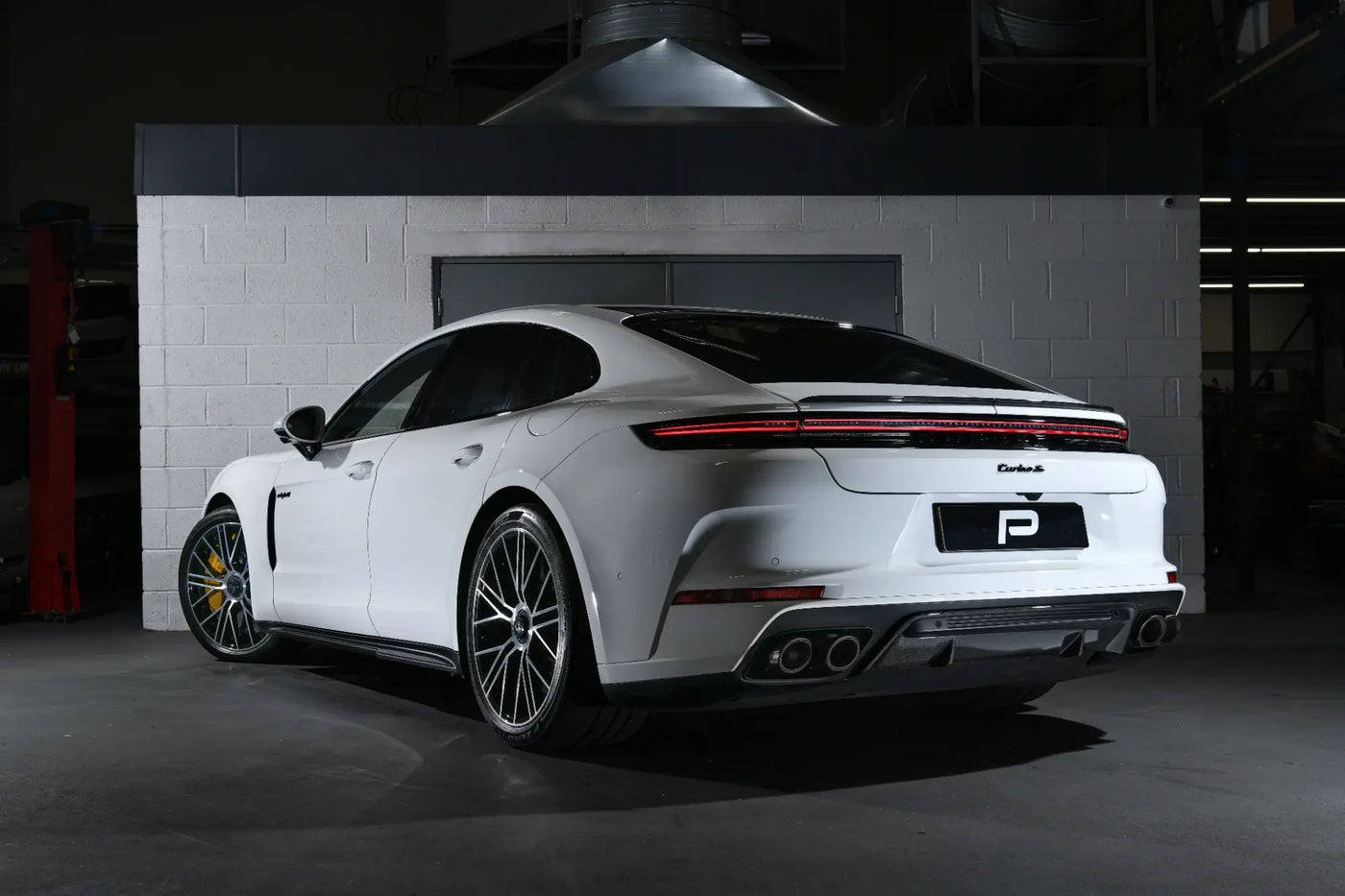 A rear angle view of the 992.1 Porsche Turbo S in the Performance Workshop with the Akrapovic performance exhaust system installed, showcasing its seamless integration and craftsmanship.