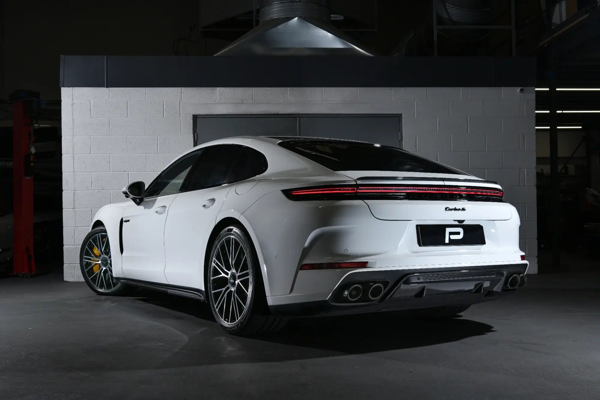 A rear angle view of the 992.1 Porsche Turbo S in the Performance Workshop with the Akrapovic performance exhaust system installed, showcasing its seamless integration and craftsmanship.