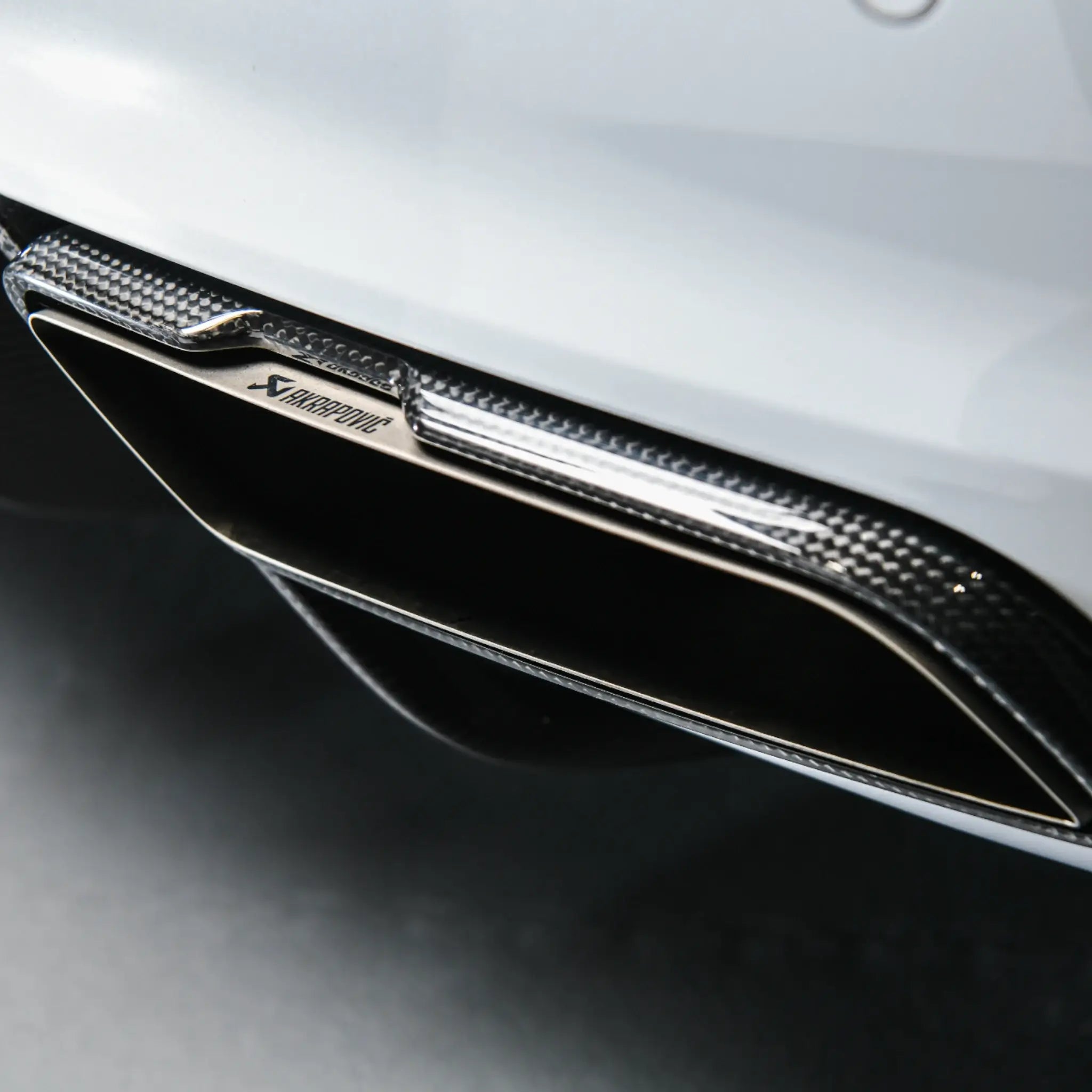 Detail shot of the Akrapovič Slip-On Line carbon fibre tailpipes, highlighting the precision finish and premium materials.