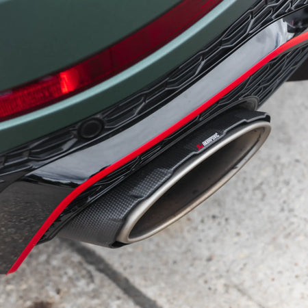 Close-up detail shot of the carbon fibre/titanium tailpipes from the Akrapovič Evolution Line (Titanium), taken outside PERON's Performance Workshop, highlighting craftsmanship and premium materials.