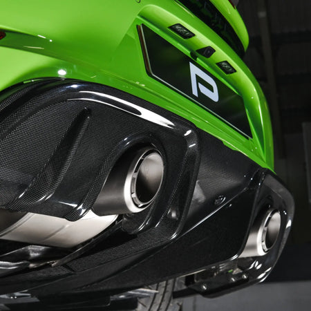 Close-up detail of the Akrapovic Slip-On Race Line and optional high gloss carbon diffuser installed on a Porsche 718 Cayman GT4 RS.