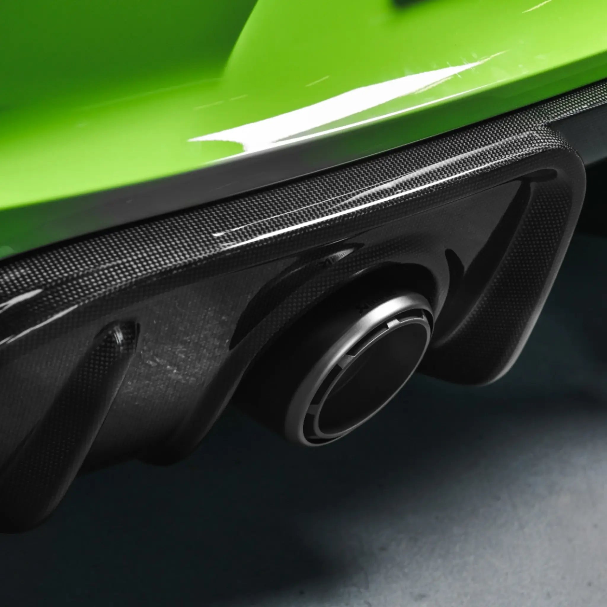 Detailed close-up showcasing the Akrapovic titanium tailpipes and high gloss carbon diffuser fitted to the Porsche 718 Cayman GT4 RS.
