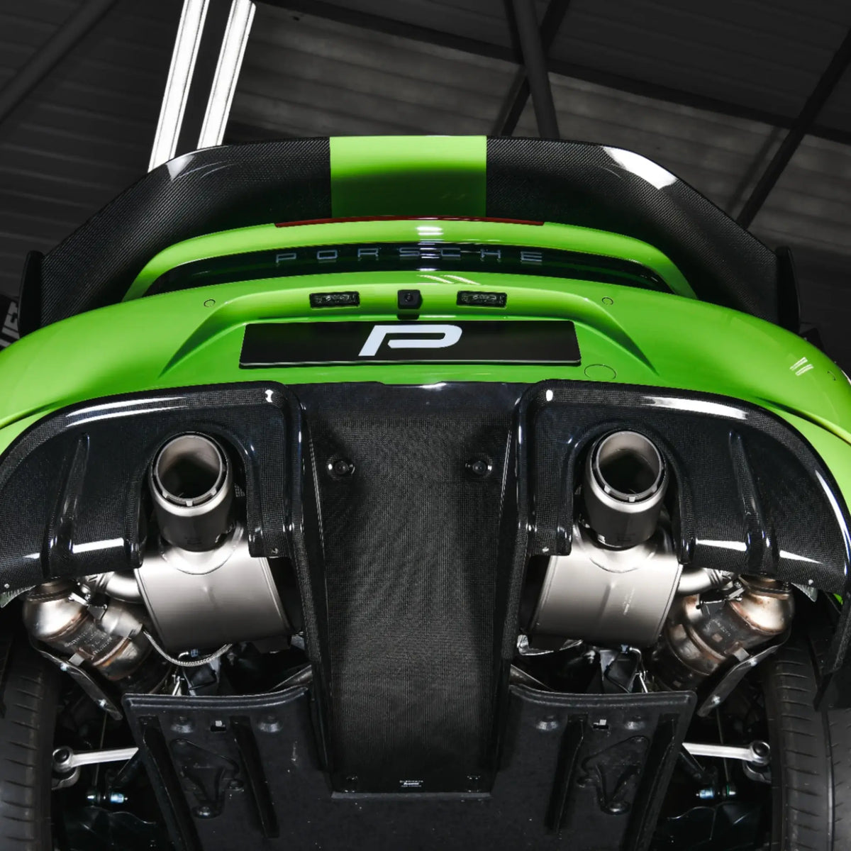Detailed underneath view highlighting the Akrapovic Slip-On Race Line system and high gloss carbon diffuser on the Porsche 718 Cayman GT4 RS.