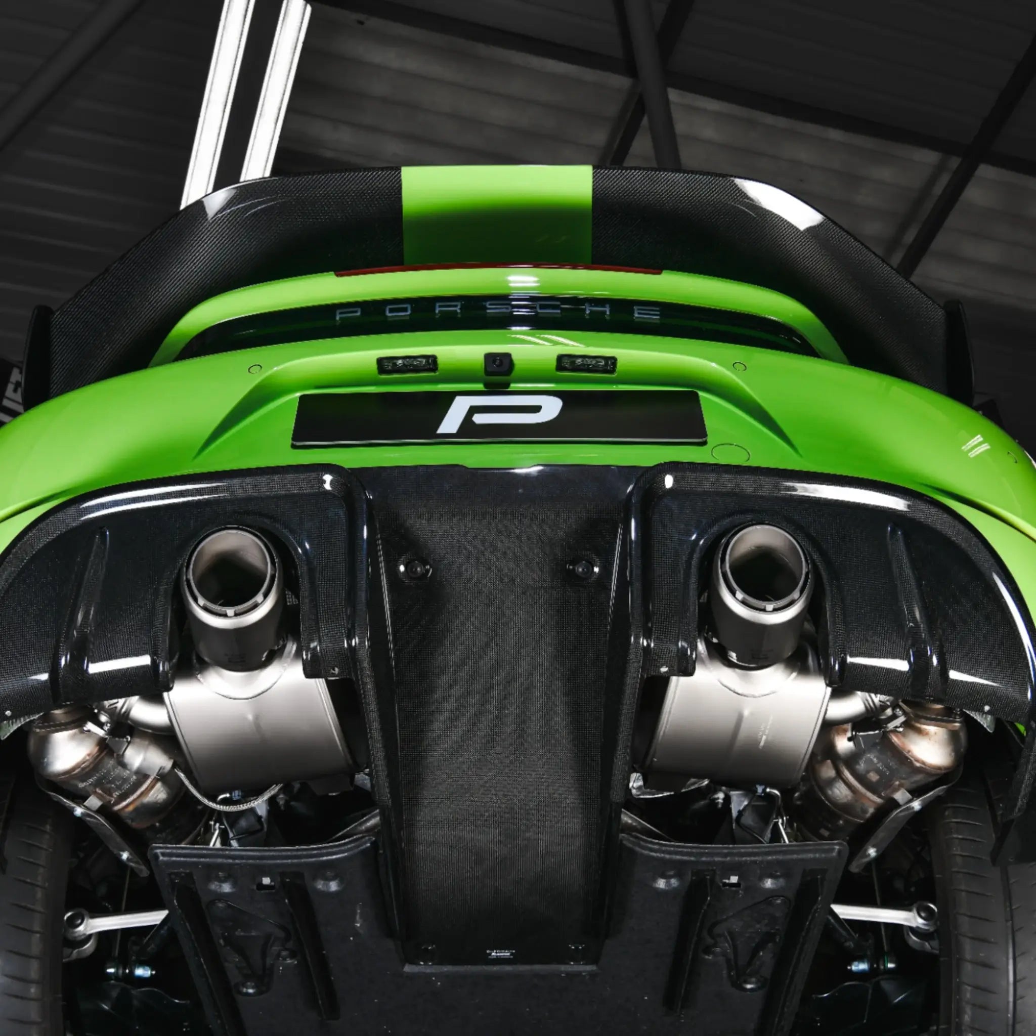 Detailed underneath view highlighting the Akrapovic Slip-On Race Line system and high gloss carbon diffuser on the Porsche 718 Cayman GT4 RS.