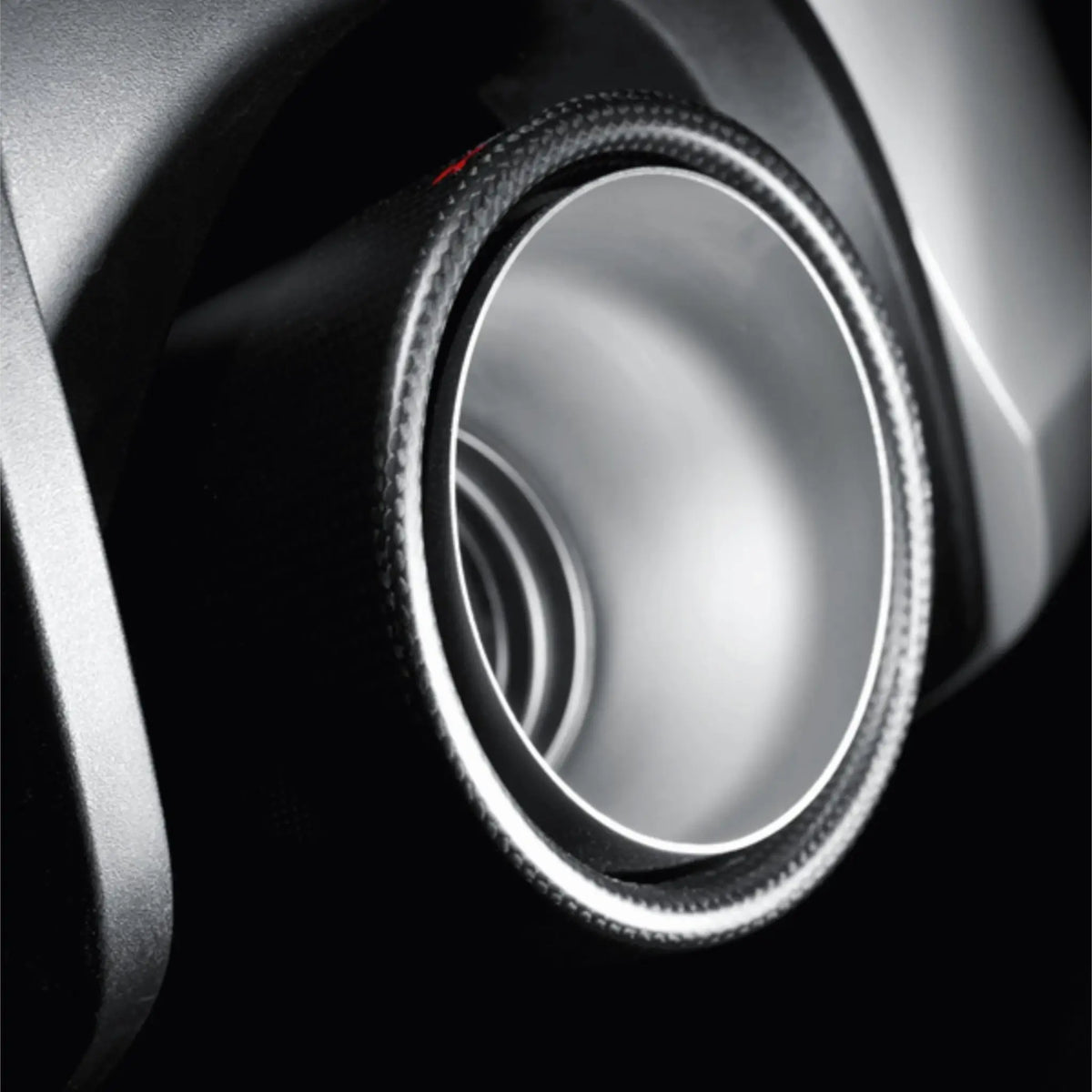 Close-up detail shot of the carbon fibre tailpipe option, emphasising the premium craftsmanship and bold aesthetic.