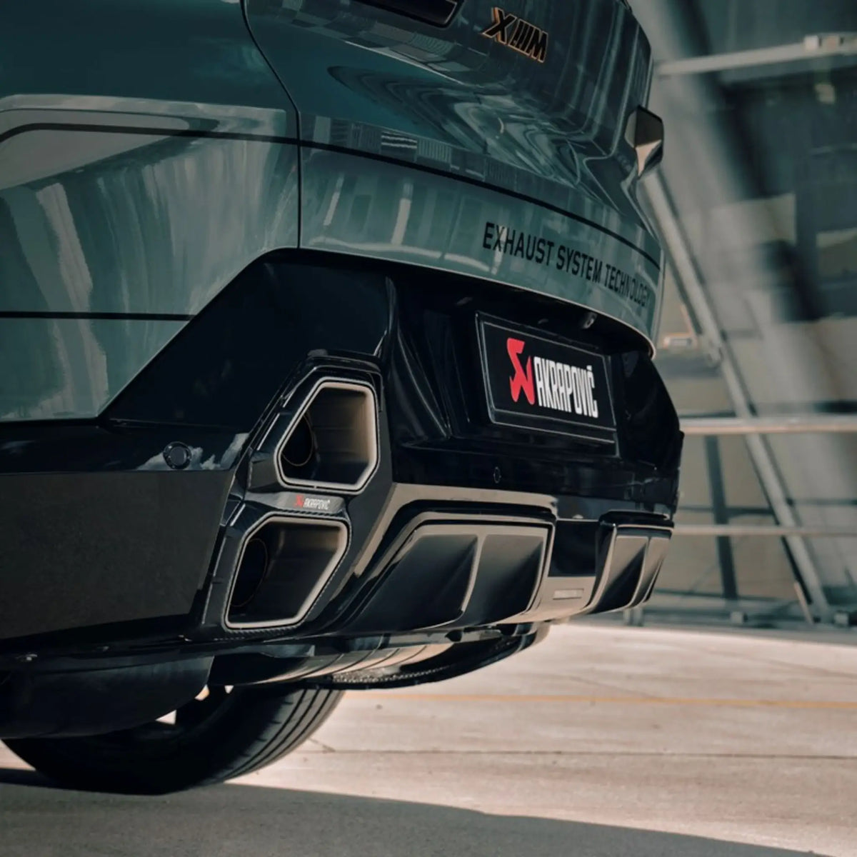 BMW XM equipped with the Akrapovič Slip-On Line (Titanium), highlighting the striking carbon tailpipes and seamless integration with the vehicle’s design.