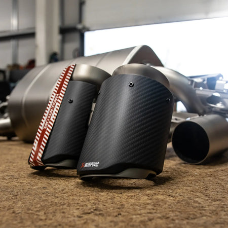 Close-up detail shot of the Akrapovic tailpipes for the F87N BMW M2, highlighting the craftsmanship and finish pre-installation.