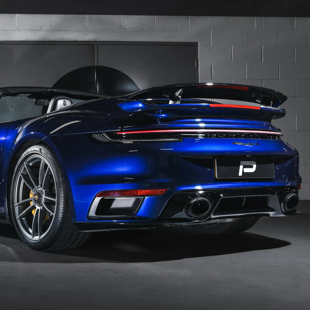 Rear-angle shot of a Porsche 911 Turbo S 992.1 in PERON Performance Workshop, fitted with the Akrapovič Slip-On Race Line (Titanium) performance exhaust.