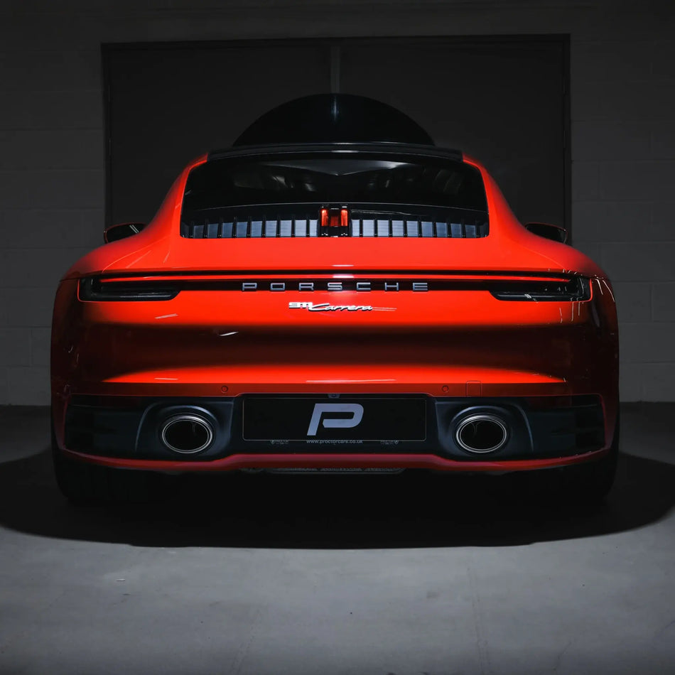 Rear head-on shot of Porsche 911 Carrera 992 in Performance Workshop post-installation of Akrapovic Slip-On Race Line exhaust.